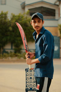 Young cricketer practicing batting stance on a sunny outdoor pitch.