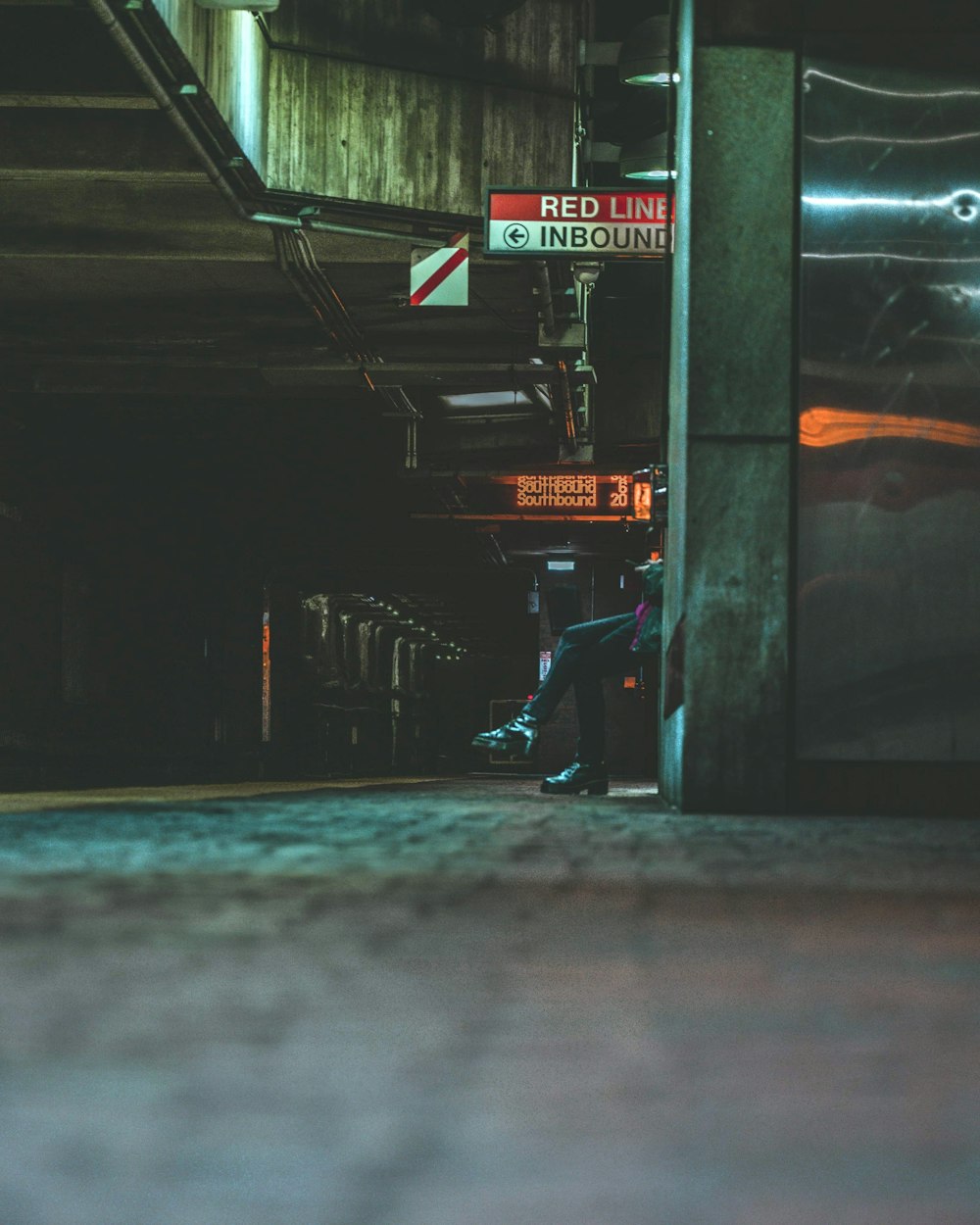 a person standing on a sidewalk next to a street sign