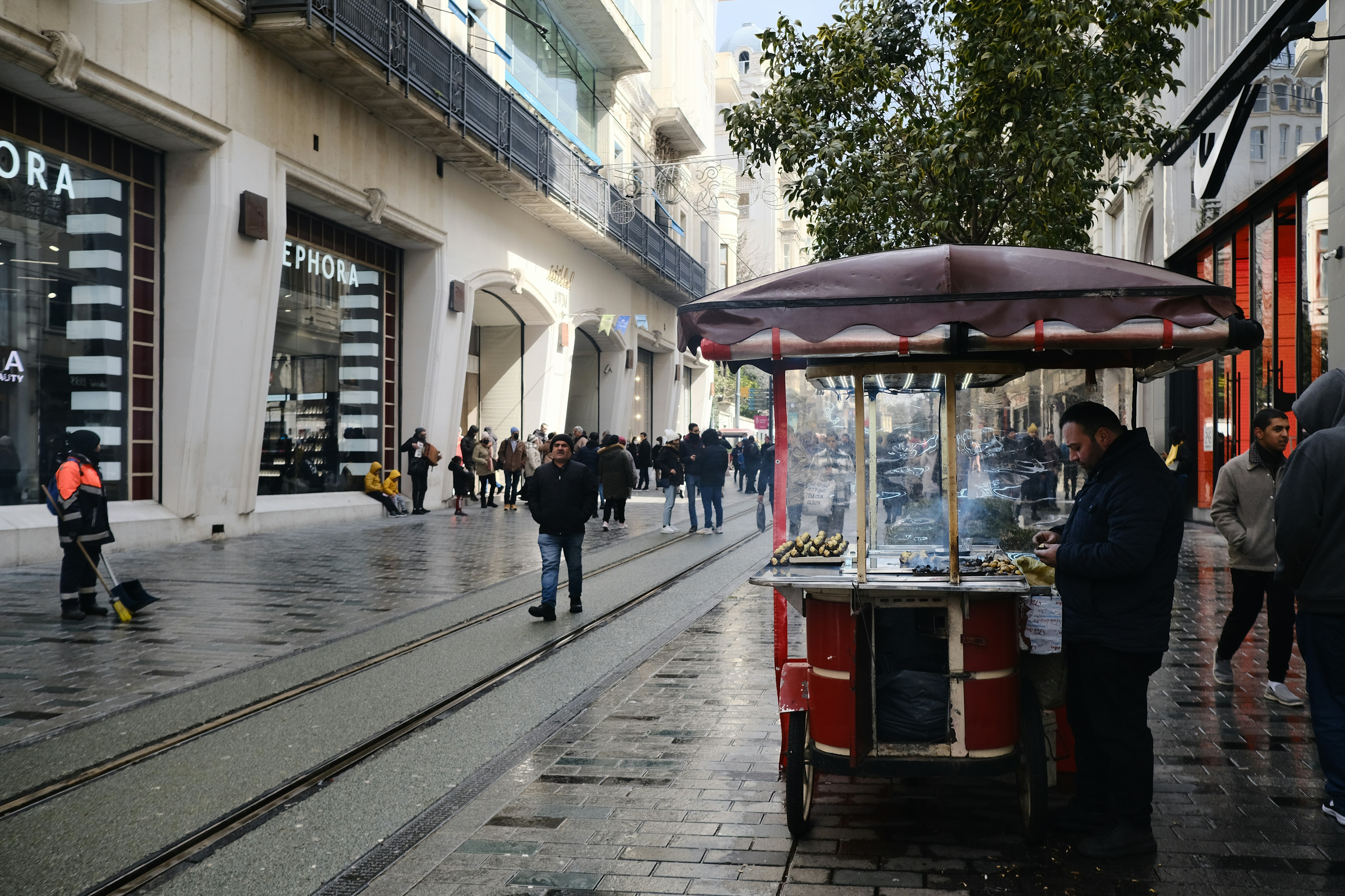 Una escena callejera con gente y un vendedor ambulante