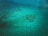Underwater drone inspecting a marine structure in clear blue water