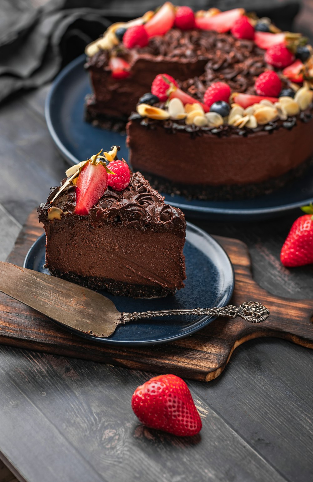 a piece of chocolate cake on a plate with strawberries