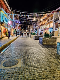 a cobblestone street in a city at night