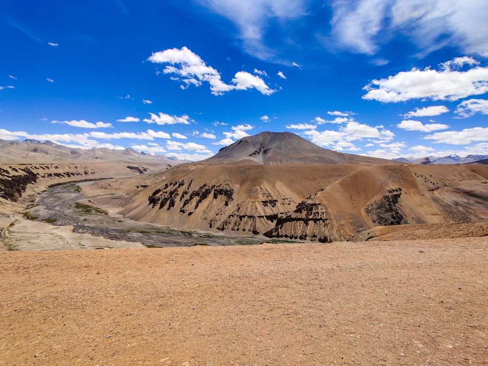 a view of a desert with a mountain in the background