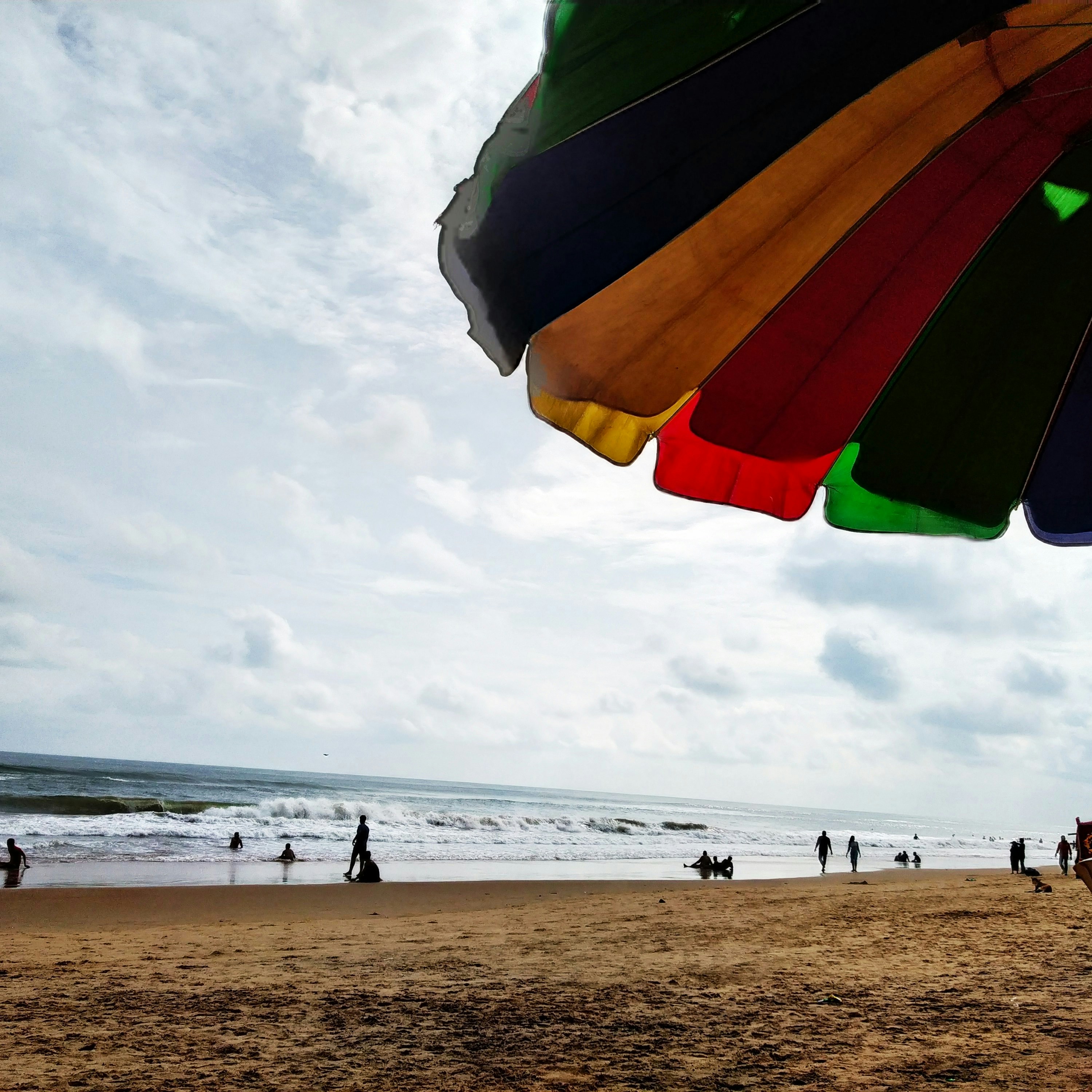 a colorful umbrella on a sandy beach near the ocean