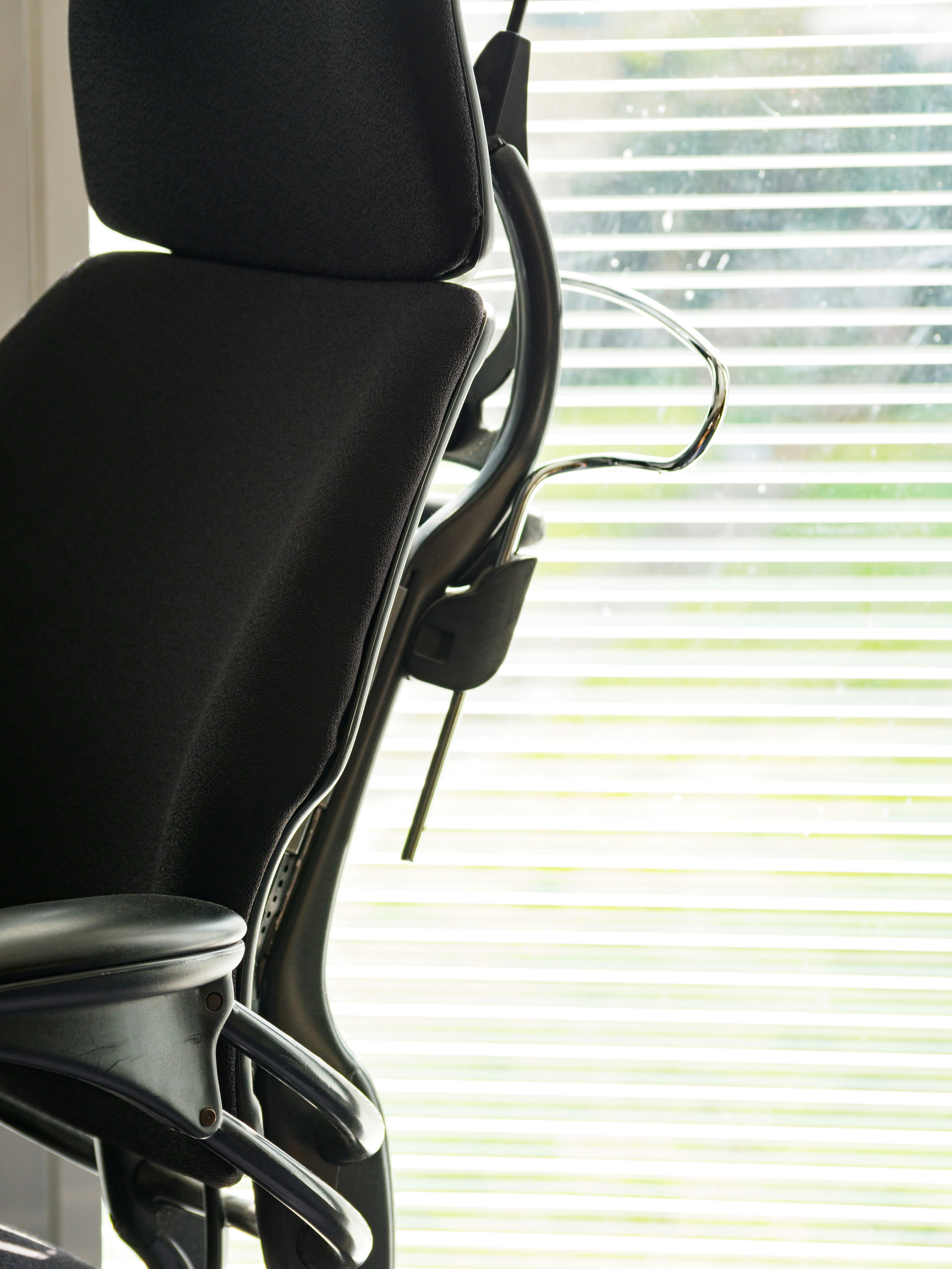 a black office chair sitting in front of a window