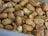 Close-up shot of roasted peanuts coated with coarse salt, showing crunchy textures and a warm, golden brown color.