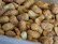 Close-up of roasted groundnuts spilling from a rustic sack onto a wooden table.