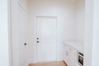 a kitchen with a white door and white cabinets