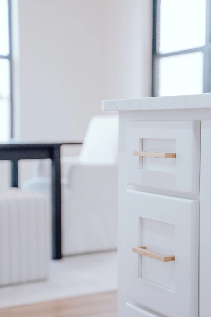 Close-up of a white kitchen cabinet drawer front and hardware, no people