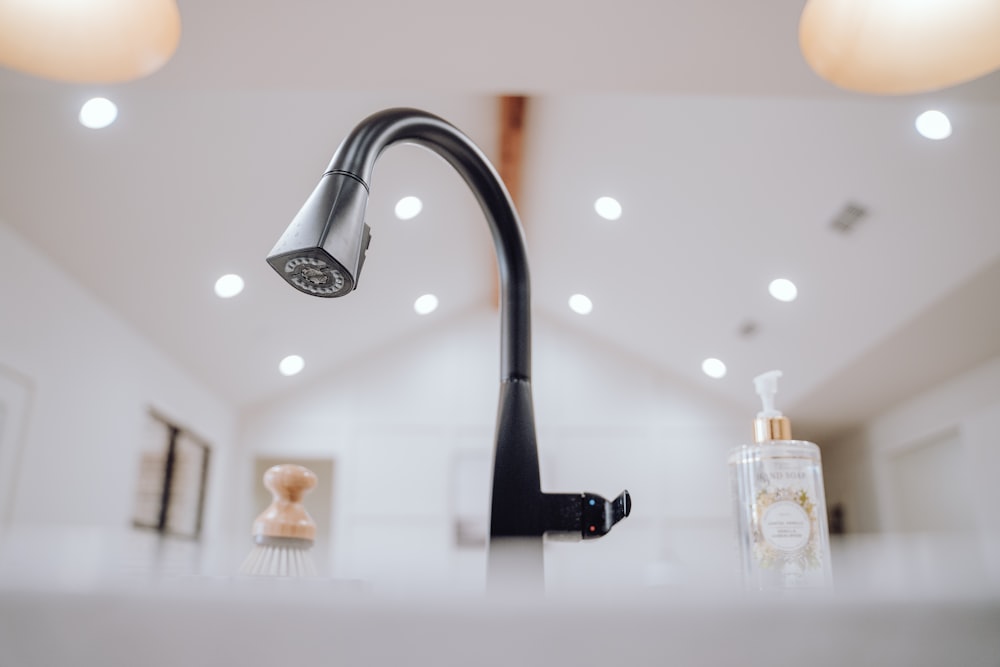 a black faucet on a white counter top