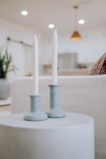 Beautifully styled candles placed among stylish home decor on a modern shelf.