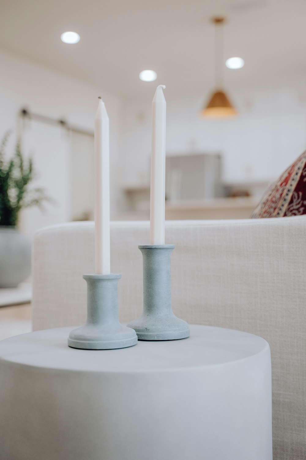 a couple of white candles sitting on top of a table