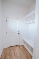 An inviting entryway scene with a shoe cabinet, padded bench, and key storage box arranged thoughtfully.