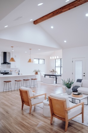 a clean living room filled with furniture and a kitchen