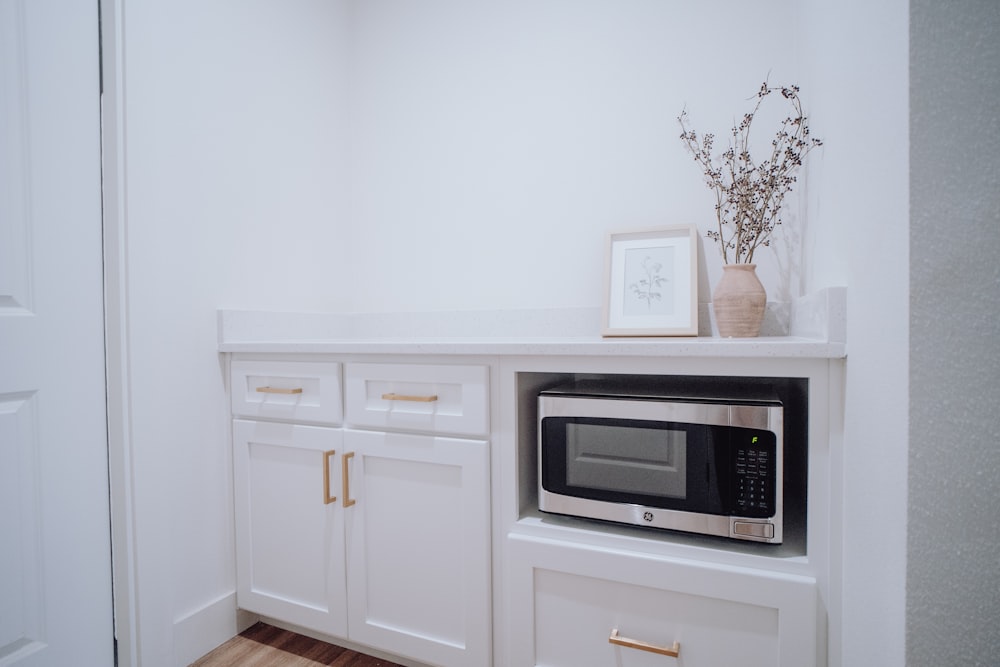 a kitchen with white cabinets and a microwave