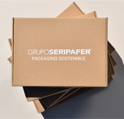 Stacked brown cardboard boxes with the text 'GRUPOSERIPAFER PACKAGING SOSTENIBLE' printed in white.