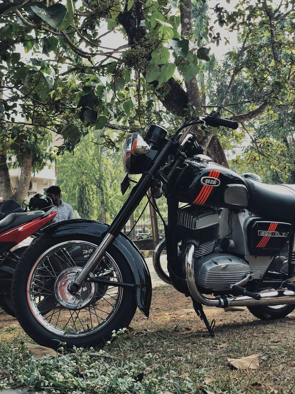 a black motorcycle parked next to a tree