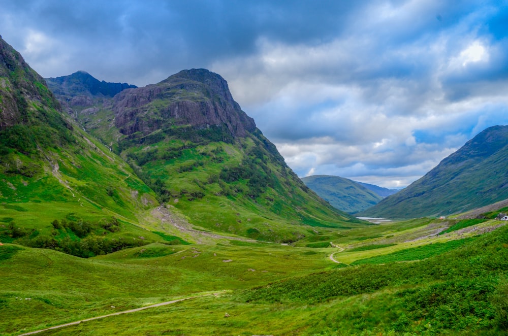 a green valley with mountains in the background