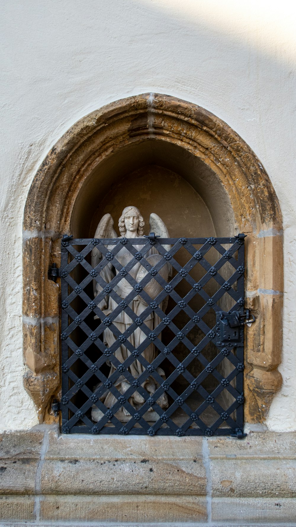 a statue of an angel behind a gate