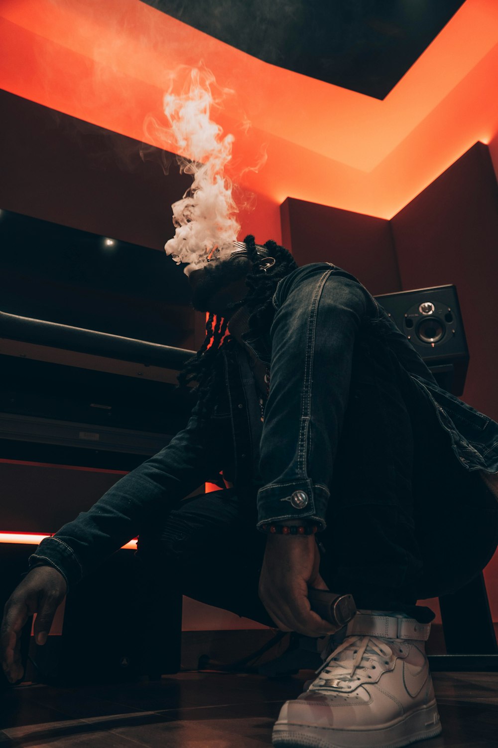 a man sitting on the floor with a cigarette in his mouth