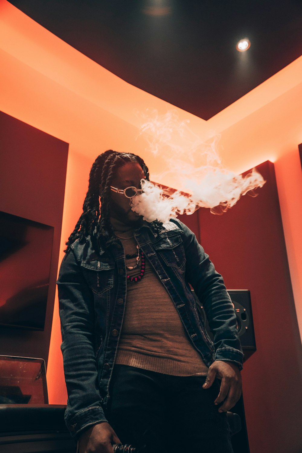 a man standing in a room with a cigarette in his mouth