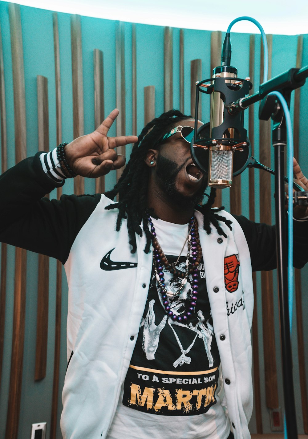 a man with dreadlocks standing in front of a microphone