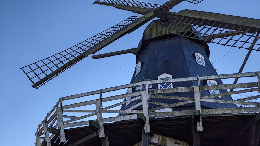 eine große blaue Windmühle auf einer Holzbrücke