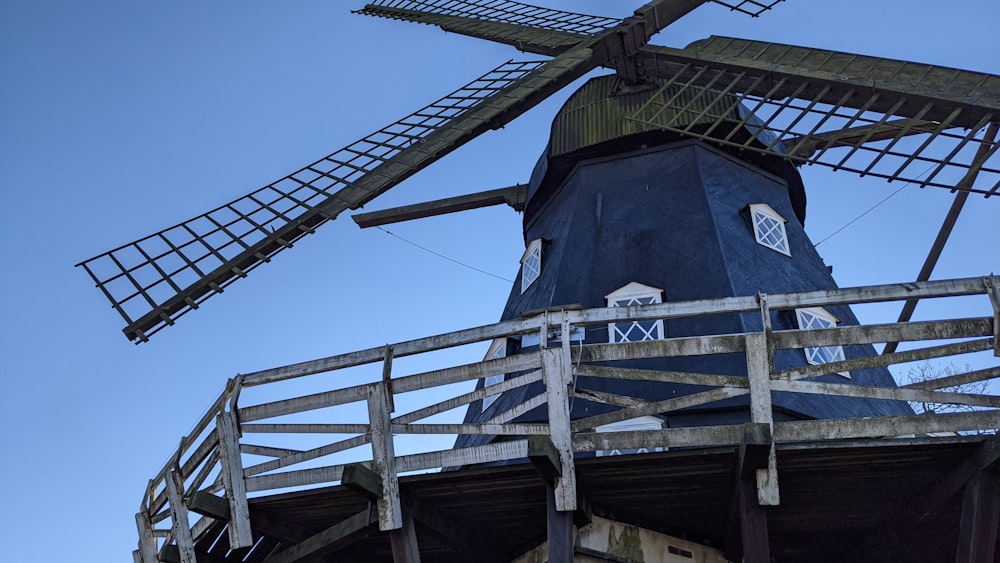 a large blue windmill sitting on top of a wooden bridge