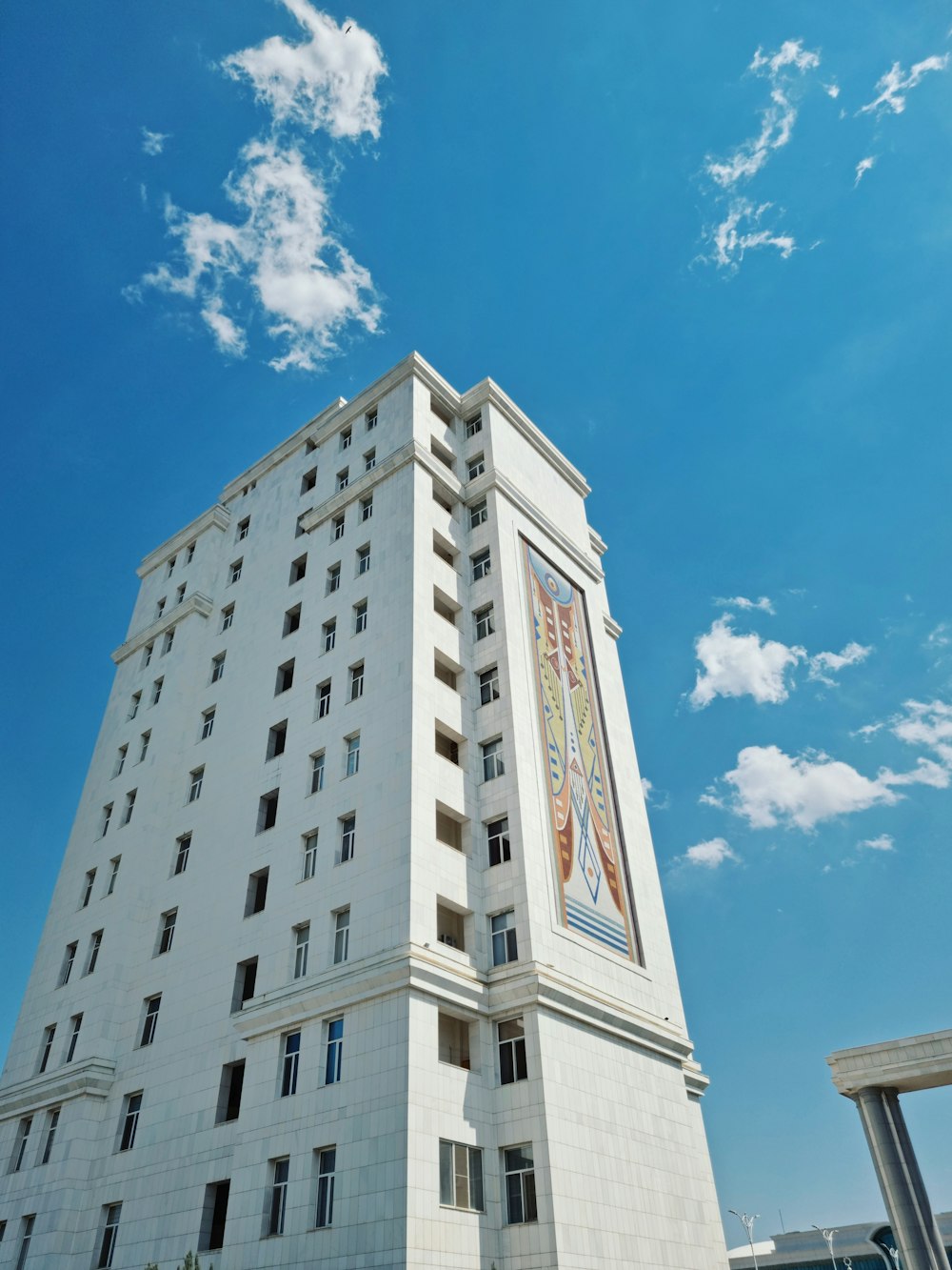 a tall white building with a blue sky in the background