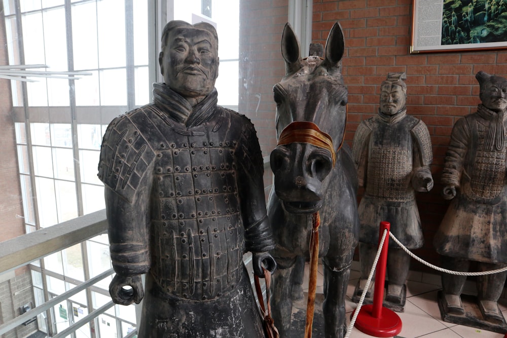 Una estatua de un hombre de pie junto a un caballo
