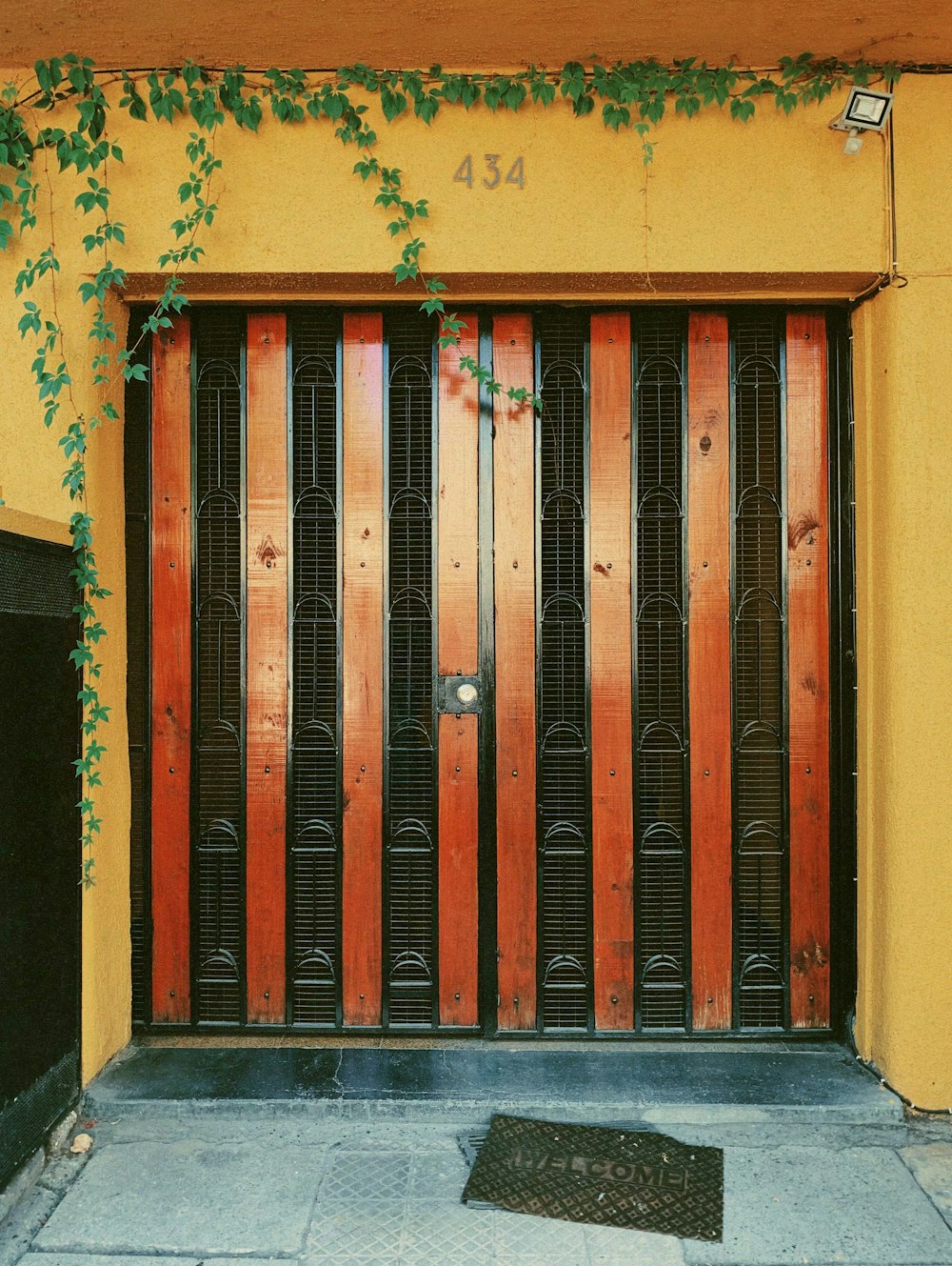 a yellow building with a red and black door