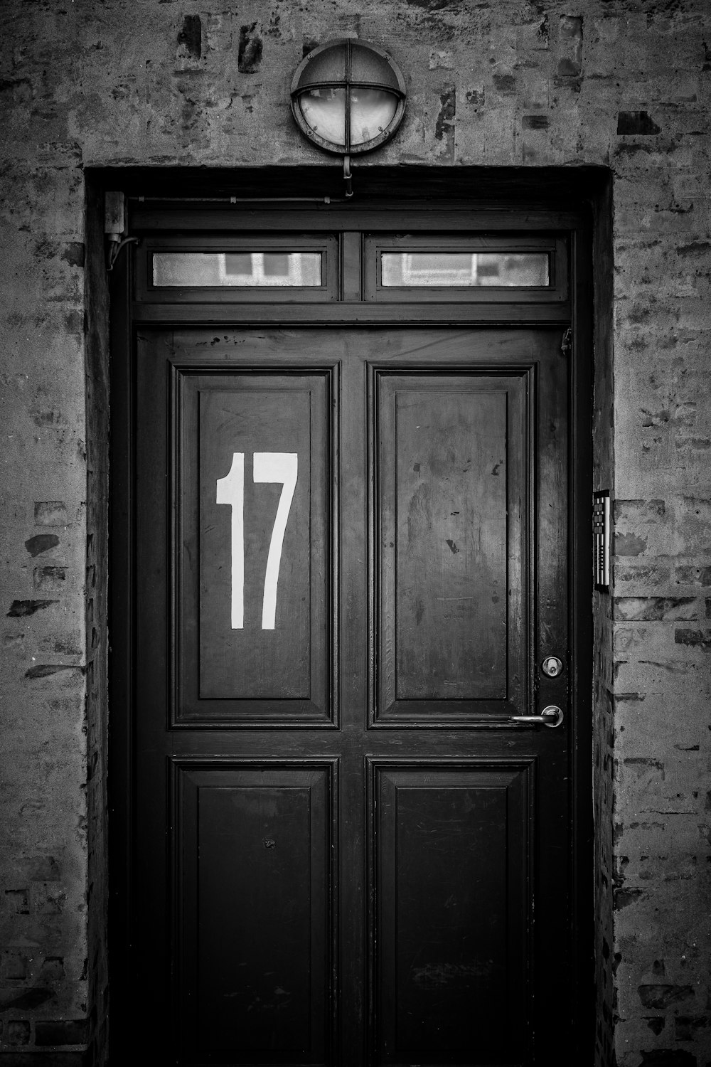 a black and white photo of a door with a clock above it