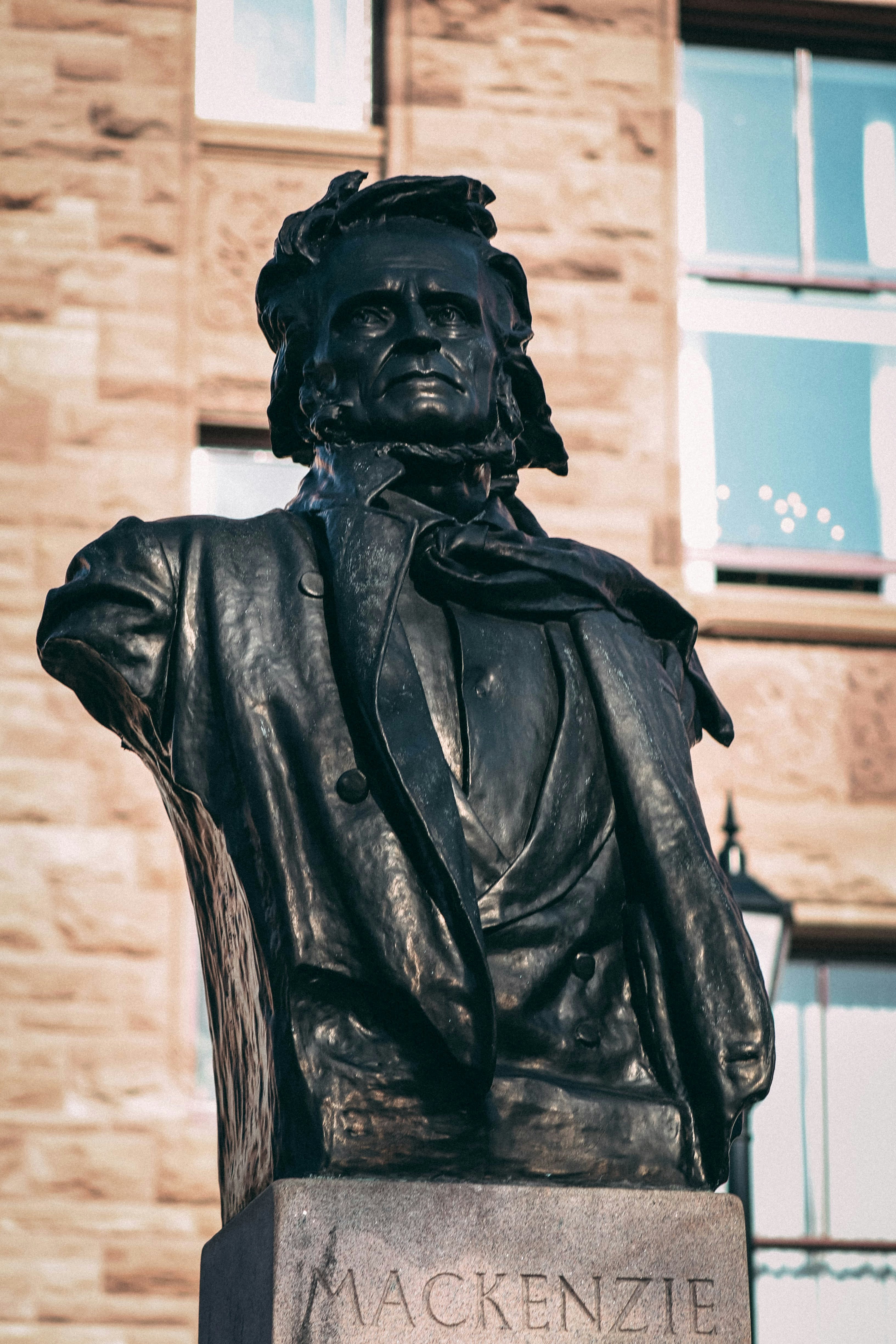 A close up of a statue of a man in front of a building