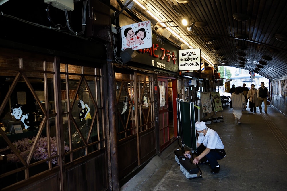 a man sitting on the ground in front of a store