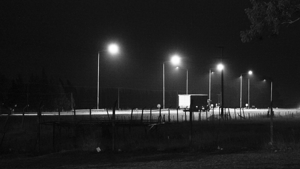 a black and white photo of a street at night