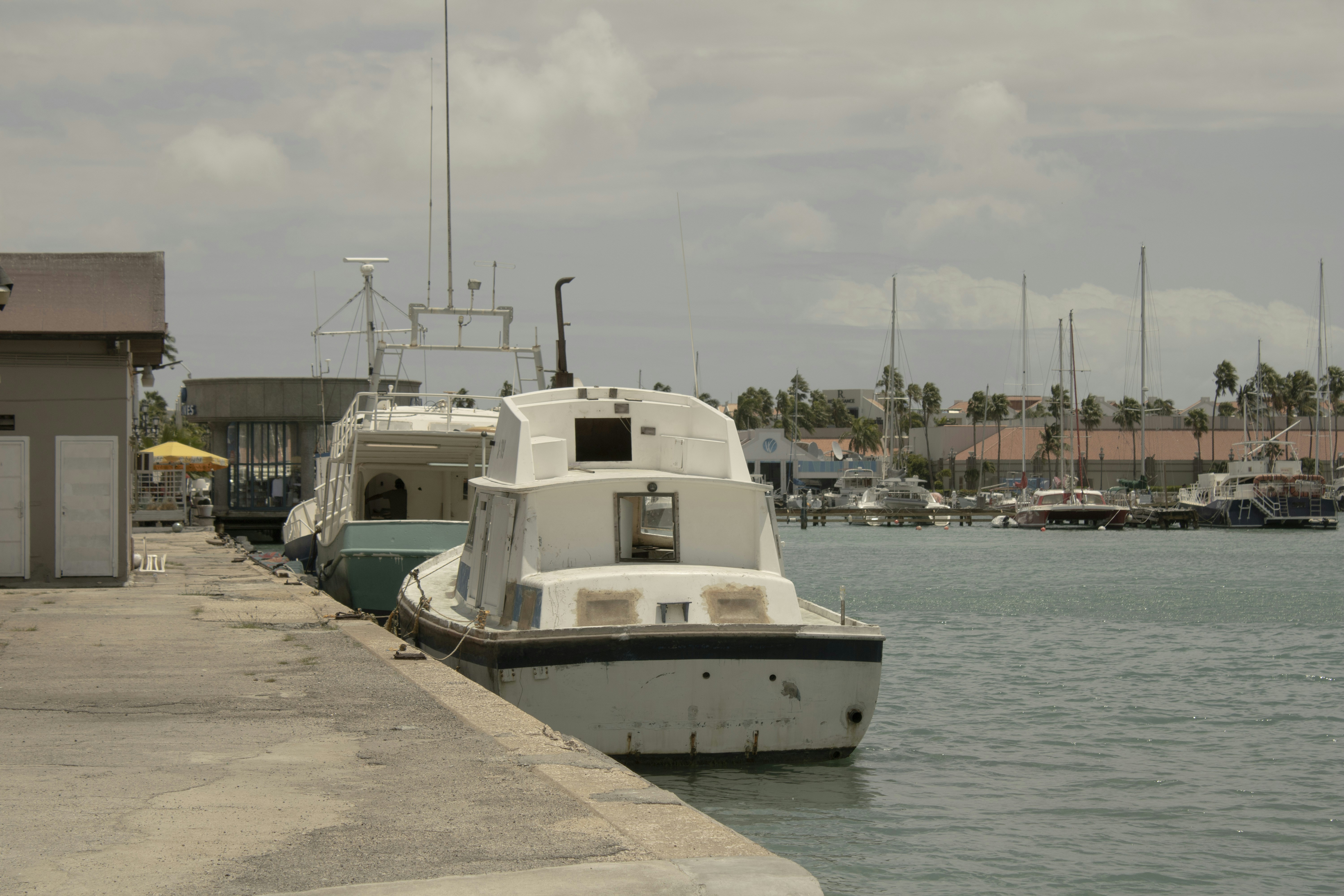 a white boat is docked at a dock