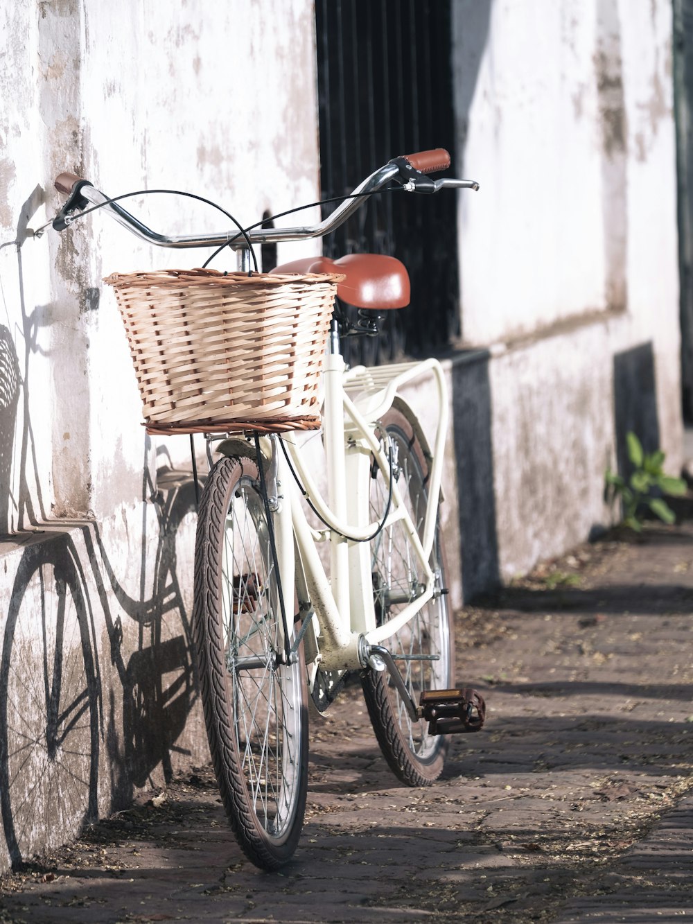 a white bicycle parked next to a white building