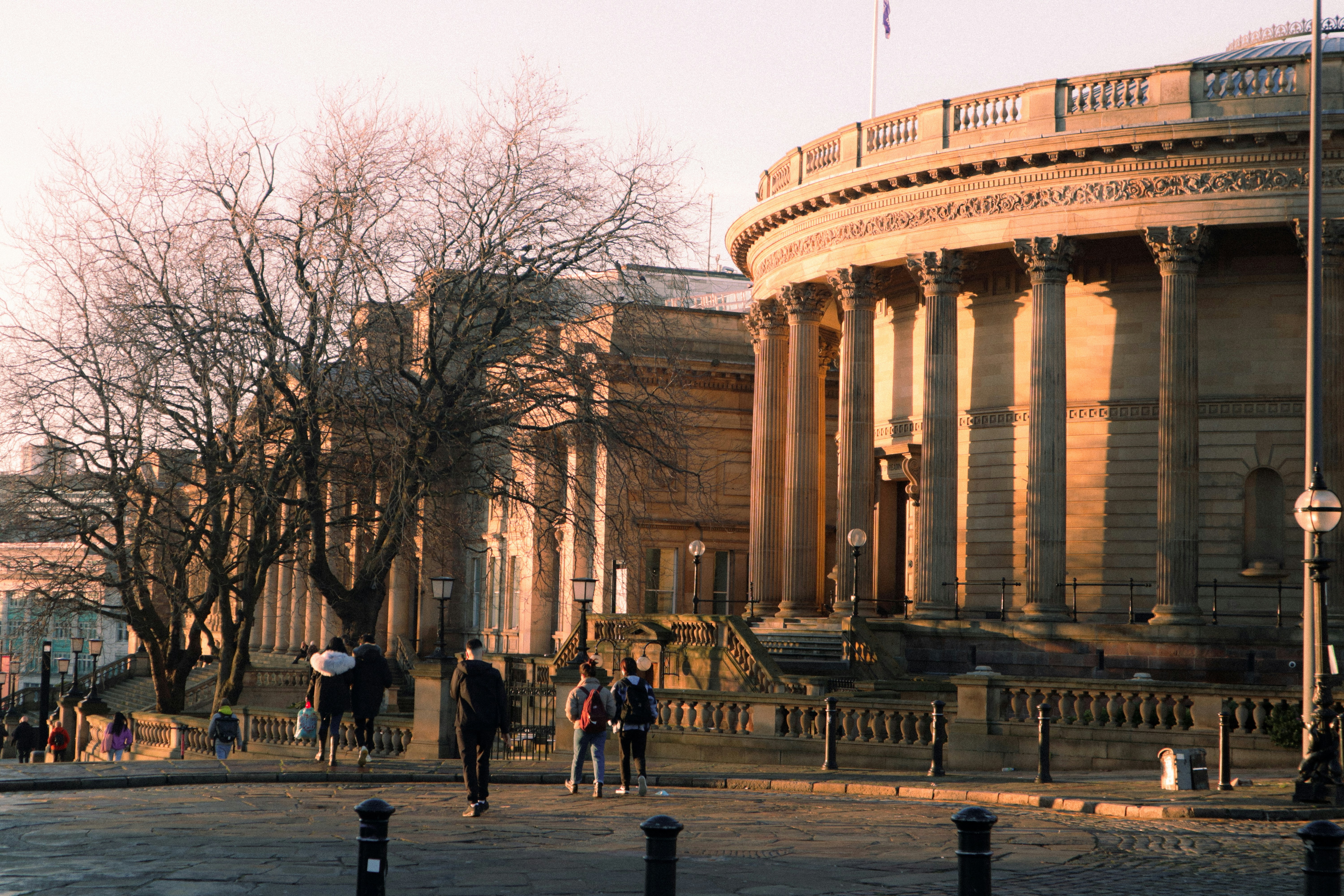 a group of people walking down a street next to tall buildings