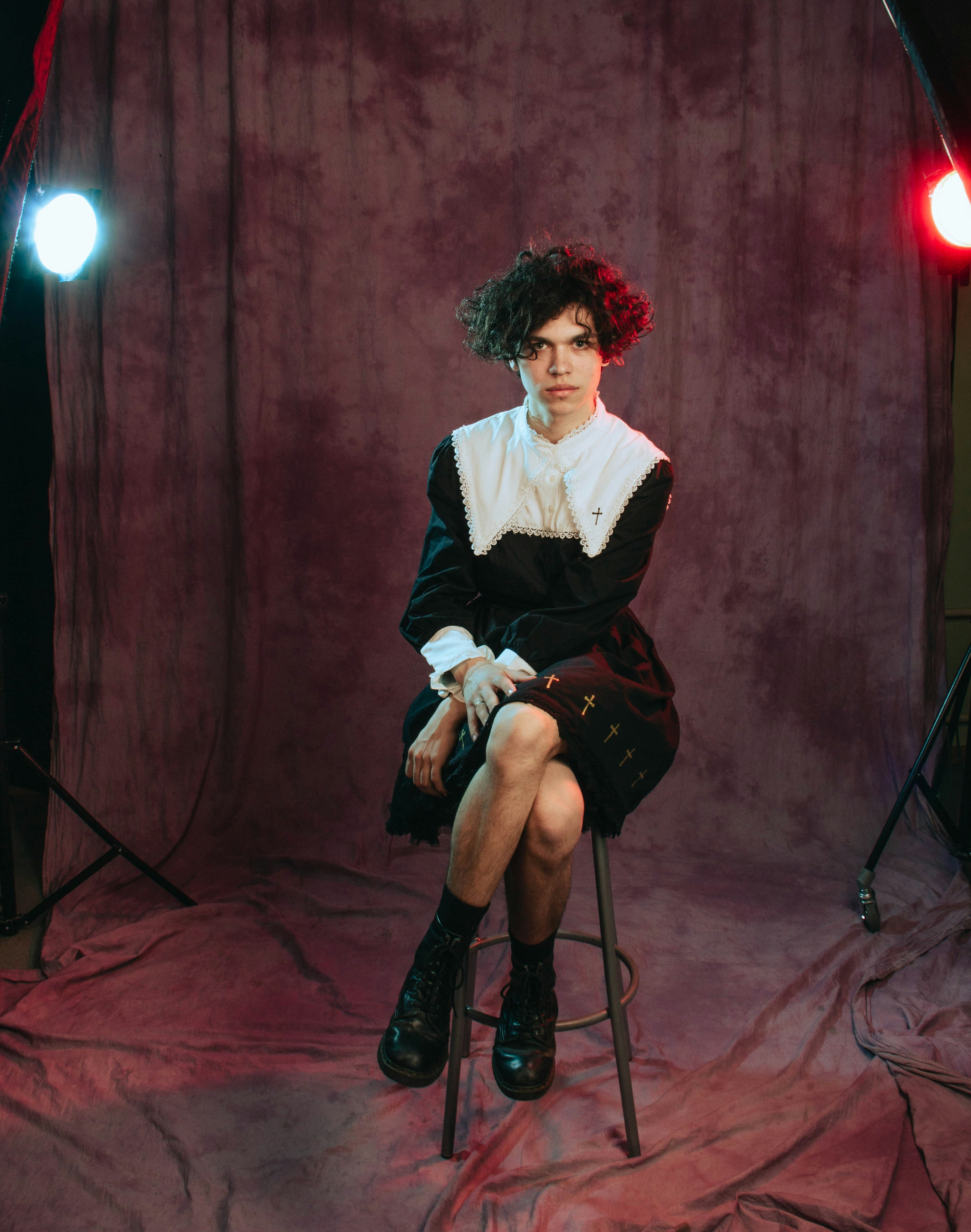 a woman sitting on a stool in a photo studio