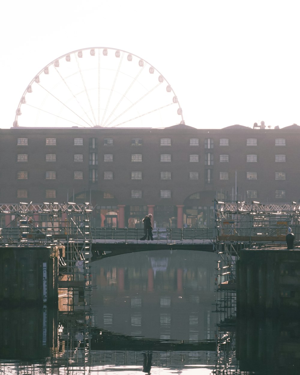 a man standing on a bridge over a body of water