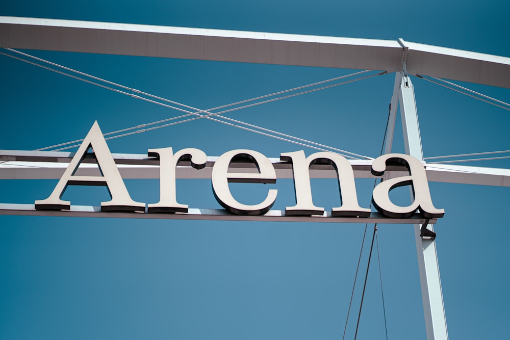 a sign that says arena hanging from the side of a bridge