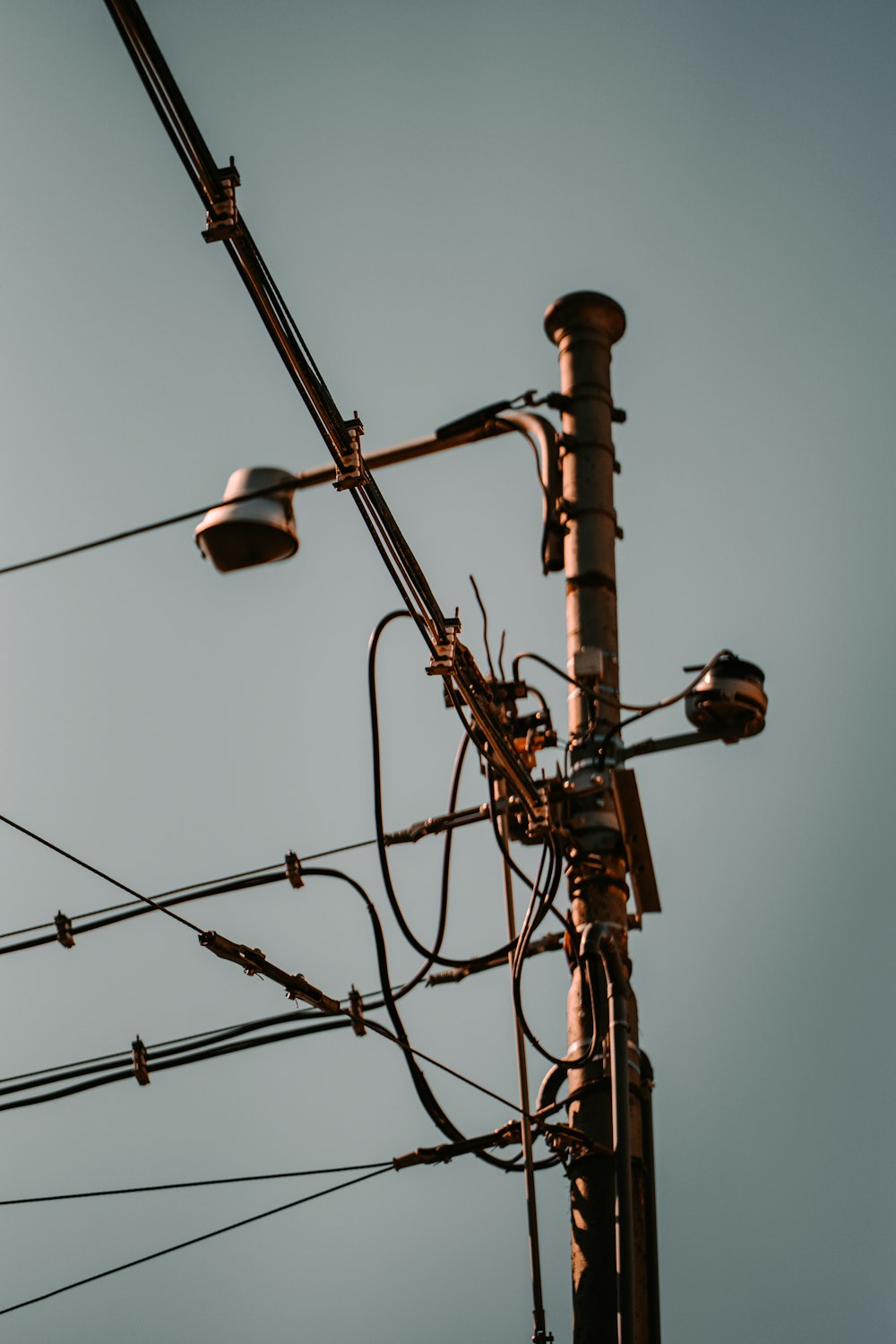 a close up of a telephone pole with many wires