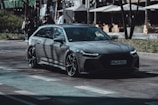 a grey car is driving down the street