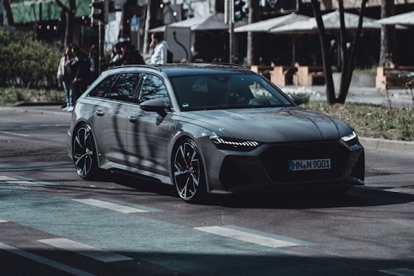 a grey car is driving down the street