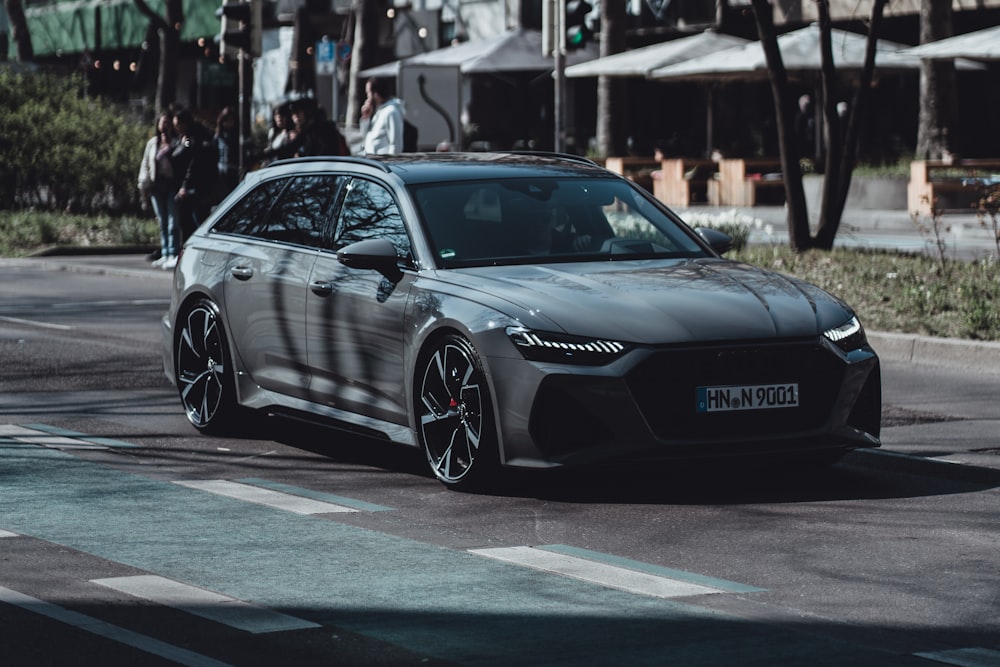 a grey car is driving down the street