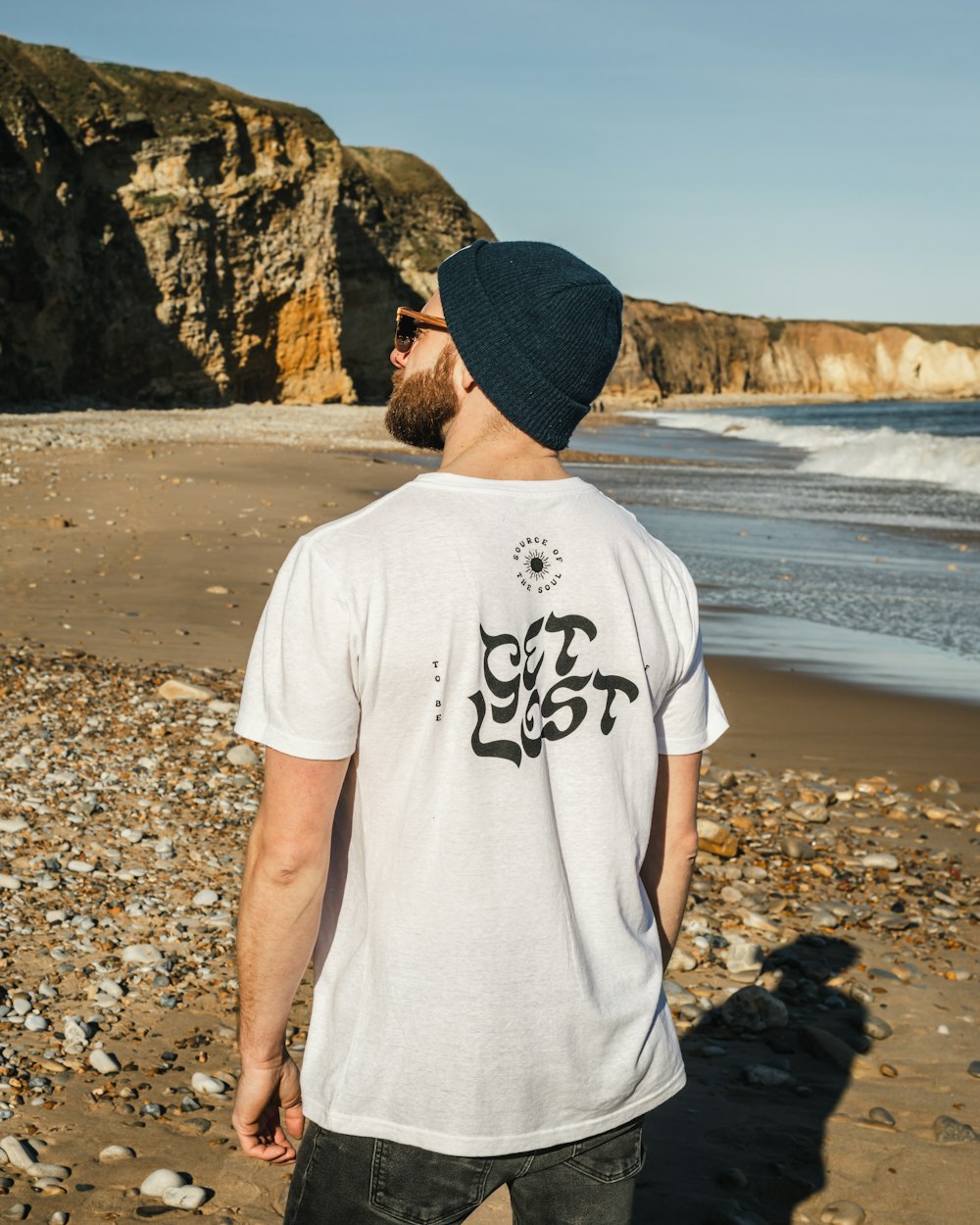 a man standing on a beach next to the ocean