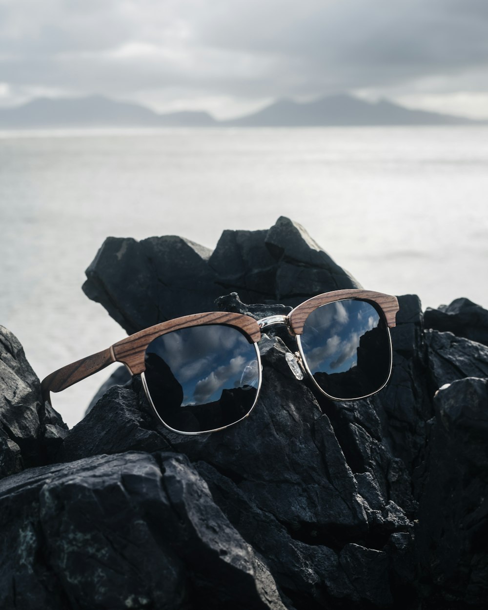 a pair of sunglasses sitting on top of a rock