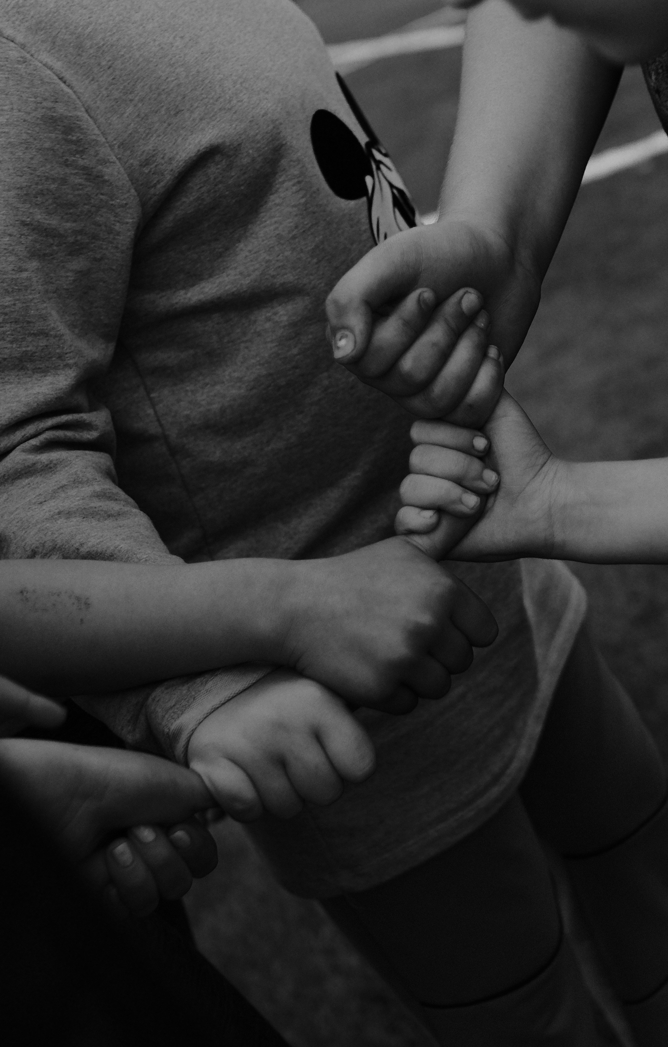 a black and white photo of a group of people holding hands