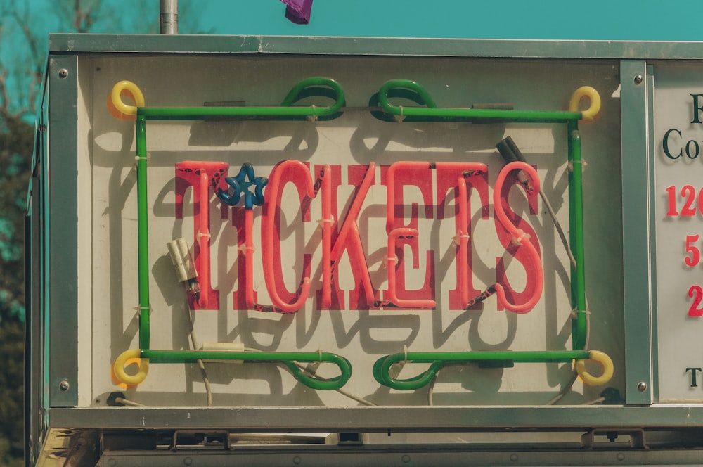 a neon sign that says tickets on the side of a building