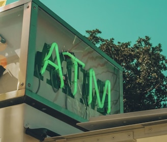 a sign that says atm on the side of a building